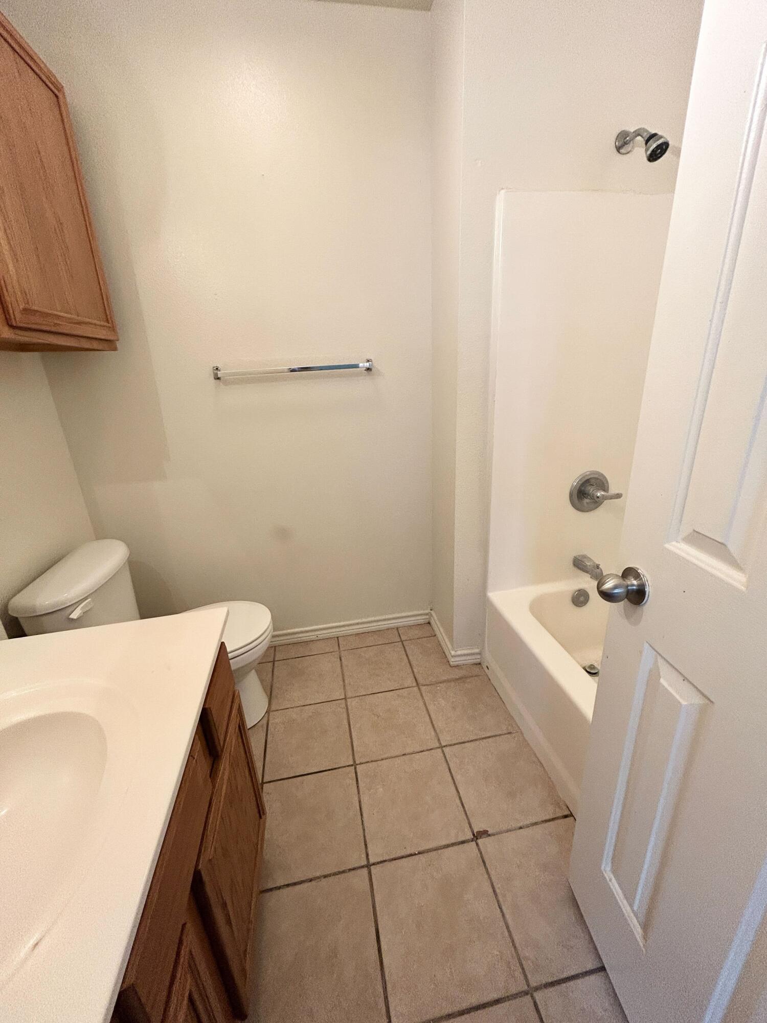 5413 Harvard Street, Unit B Lubbock, TX 79416 - Photo 6 of 10 a bathroom with a sink a toilet and bathtub