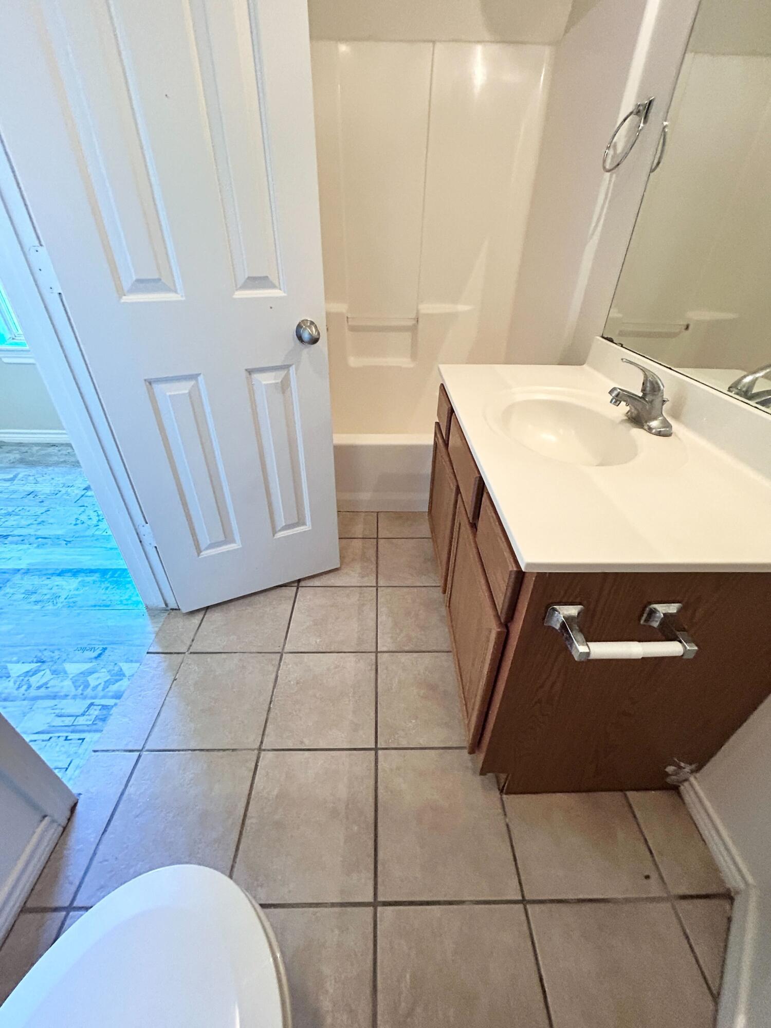 5413 Harvard Street, Unit B Lubbock, TX 79416 - Photo 8 of 10 a bathroom with a sink a toilet and a mirror
