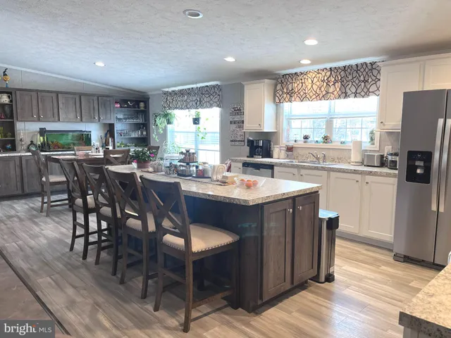 a kitchen with refrigerator a sink and chairs
