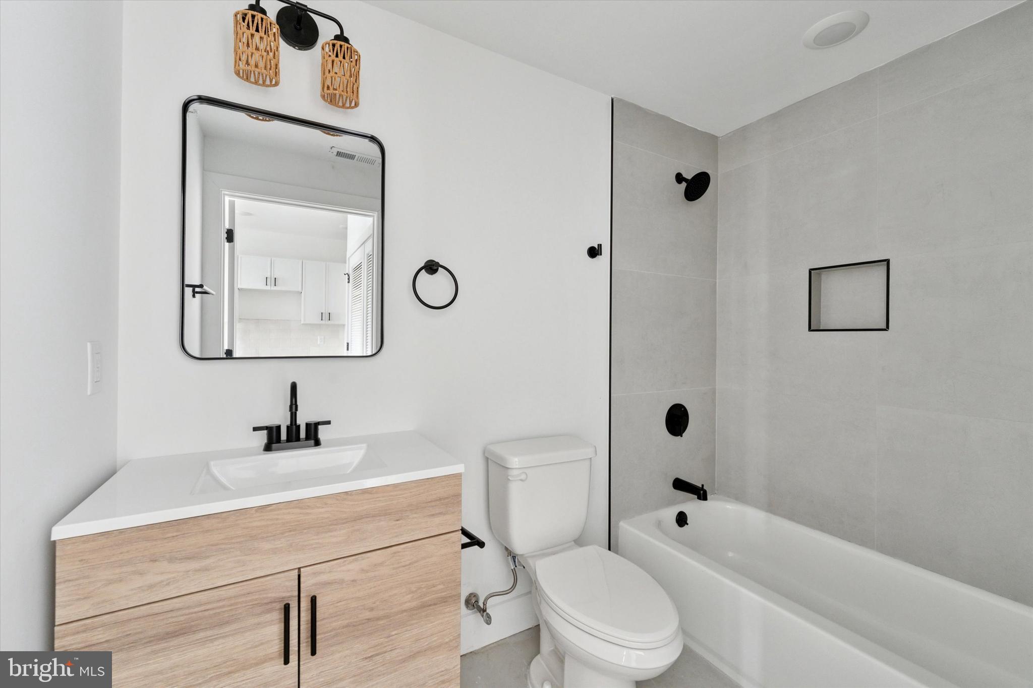 2520 North Front Street, Unit 403 Philadelphia, PA 19133 - Photo 4 of 8 a bathroom with a toilet sink vanity tub and mirror