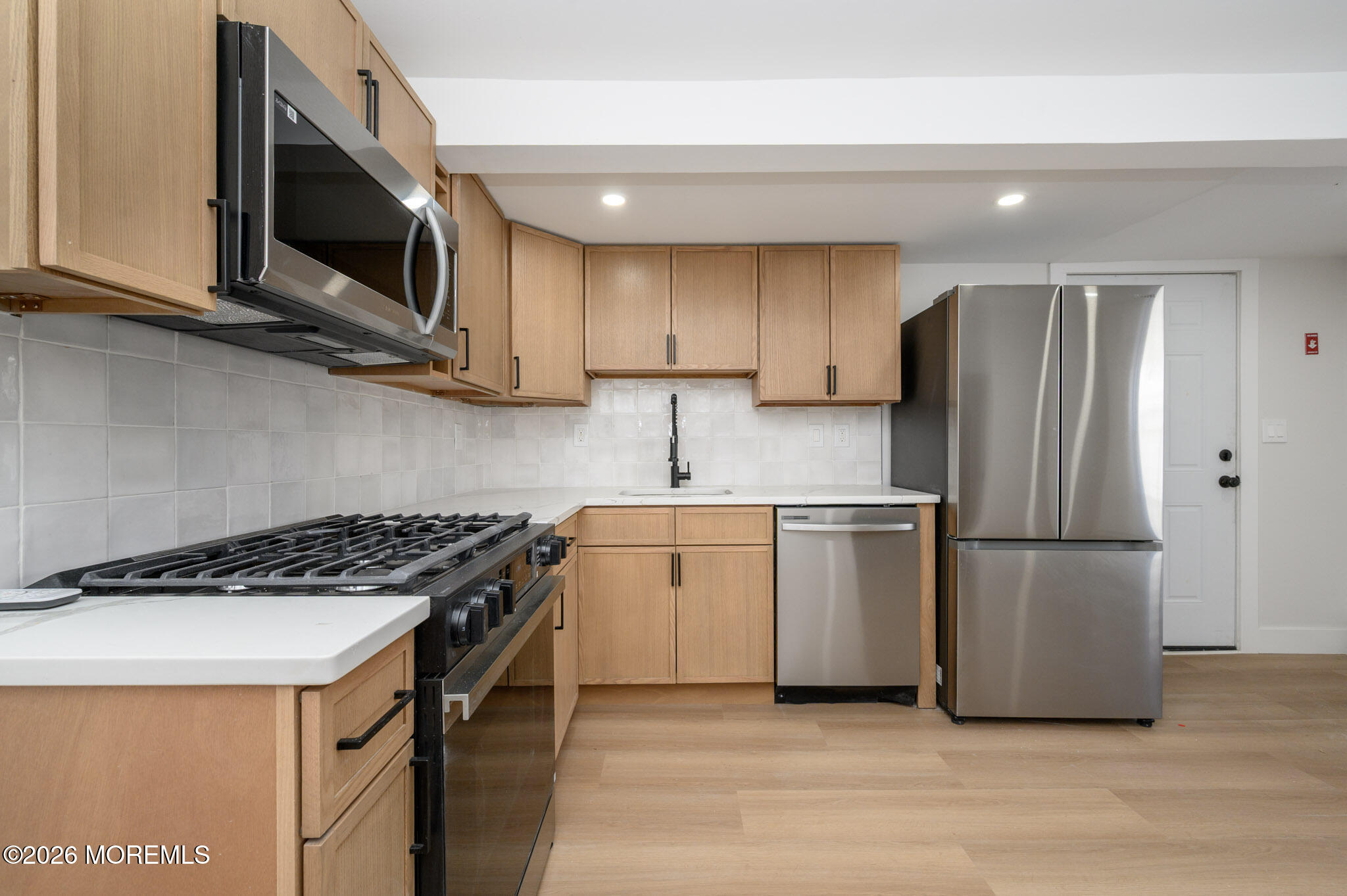8 Orchard Street Matawan, NJ 07747 - Photo 20 of 34 a kitchen with a sink a microwave a refrigerator and cabinets