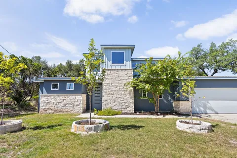 a kitchen with granite countertop a sink dishwasher stove and microwave with wooden floor