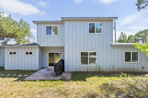 a front view of a house with a yard and tree