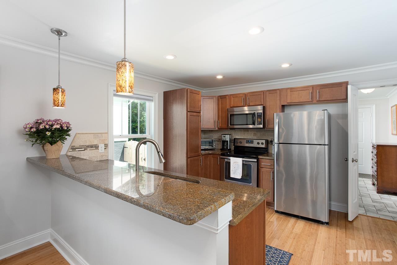 1509 South Roxboro Street Durham, NC 27707 - Photo 8 of 30 a kitchen with stainless steel appliances granite countertop a refrigerator a sink dishwasher a oven a large island with wooden floor and cabinets