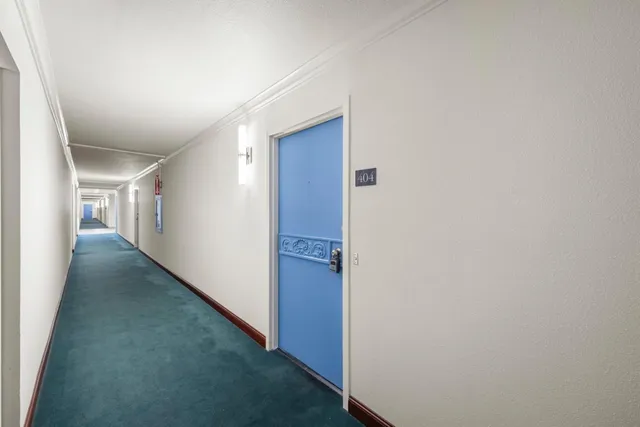 a kitchen with granite countertop white cabinets and refrigerator