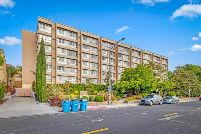 a view of a street with potted plants