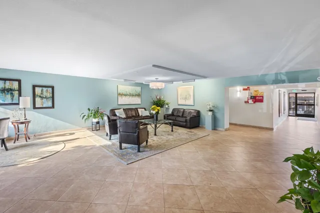 a living room with furniture and potted plants