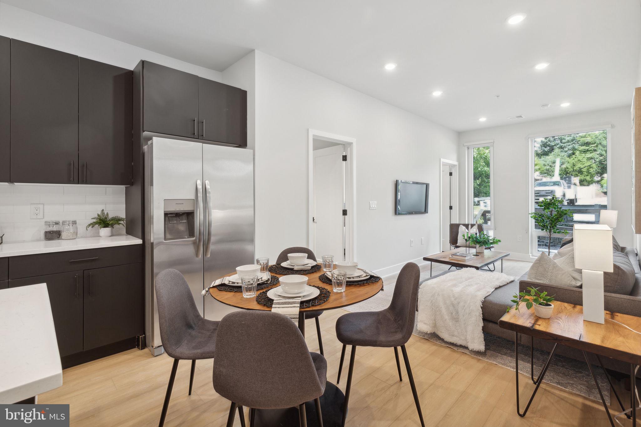 a living room with stainless steel appliances kitchen island granite countertop furniture and a refrigerator