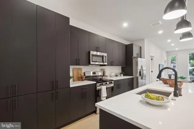 a kitchen with a sink a stove and chairs