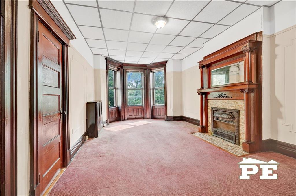 286 Windsor Place Brooklyn, NY 11218 - Photo 27 of 50 a view of an empty room with a fireplace and a window