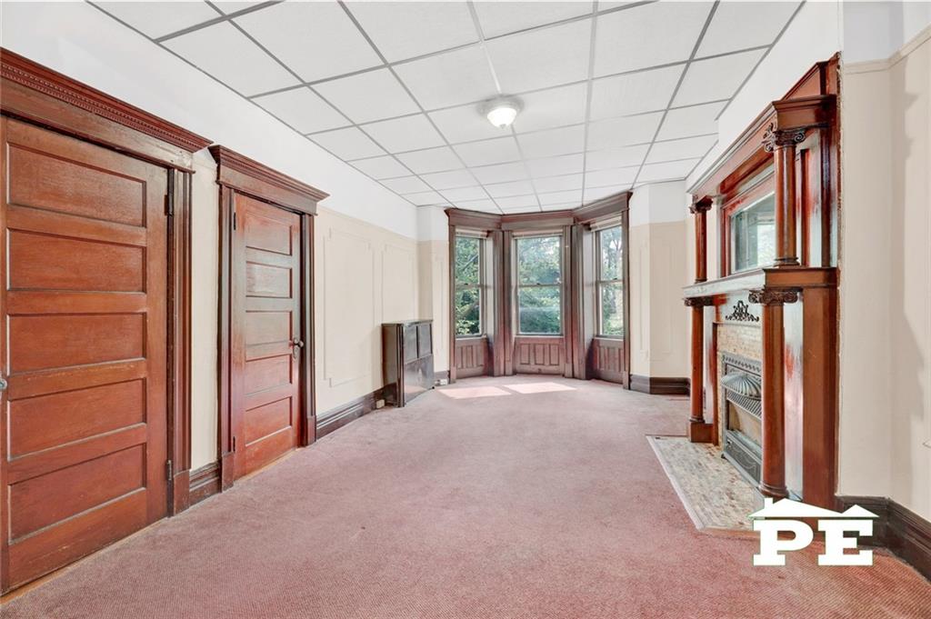 286 Windsor Place Brooklyn, NY 11218 - Photo 30 of 50 a view of an empty room with a fireplace and windows