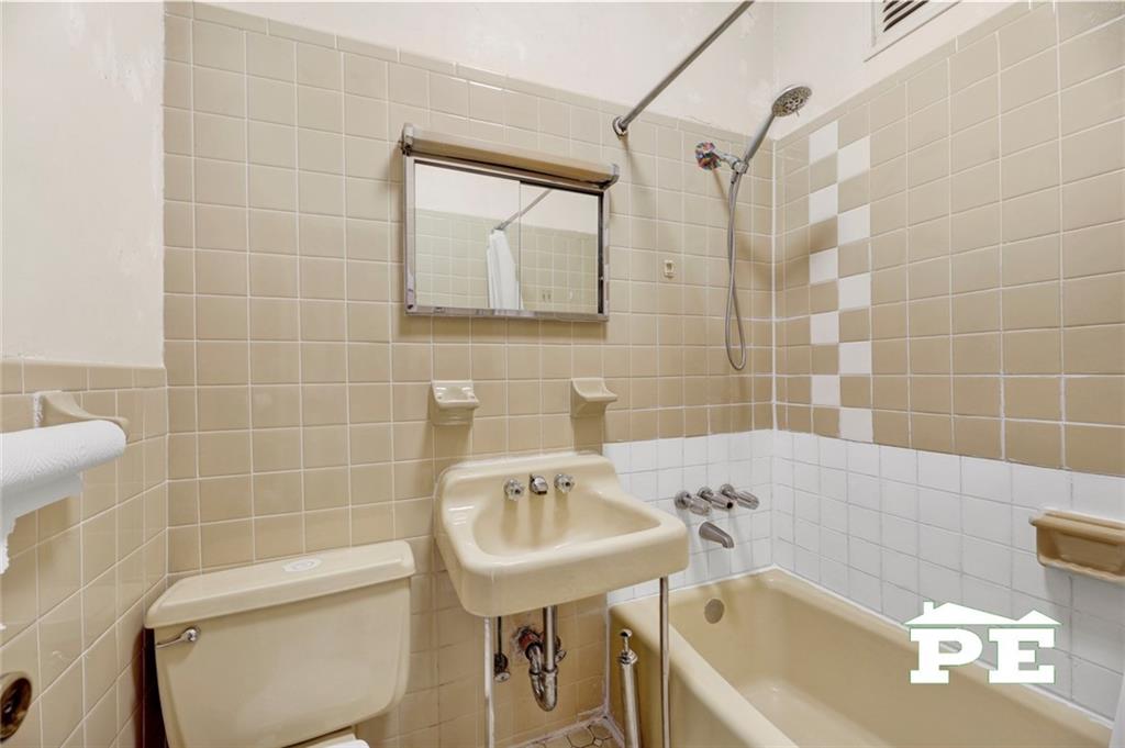 286 Windsor Place Brooklyn, NY 11218 - Photo 42 of 50 a bathroom with a sink a toilet a mirror and bathtub