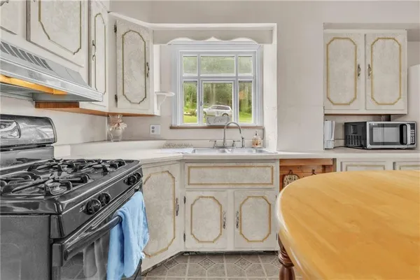 a kitchen with stainless steel appliances granite countertop a stove a sink and a microwave