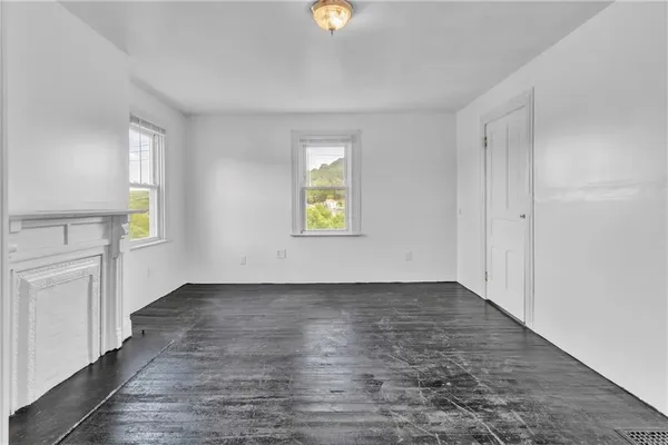 an empty room with windows and cabinet