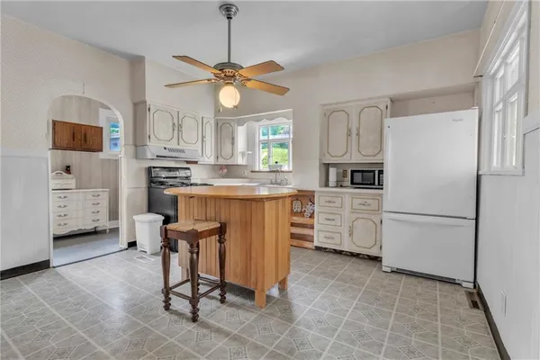 a kitchen with cabinets a counter space appliances and a window