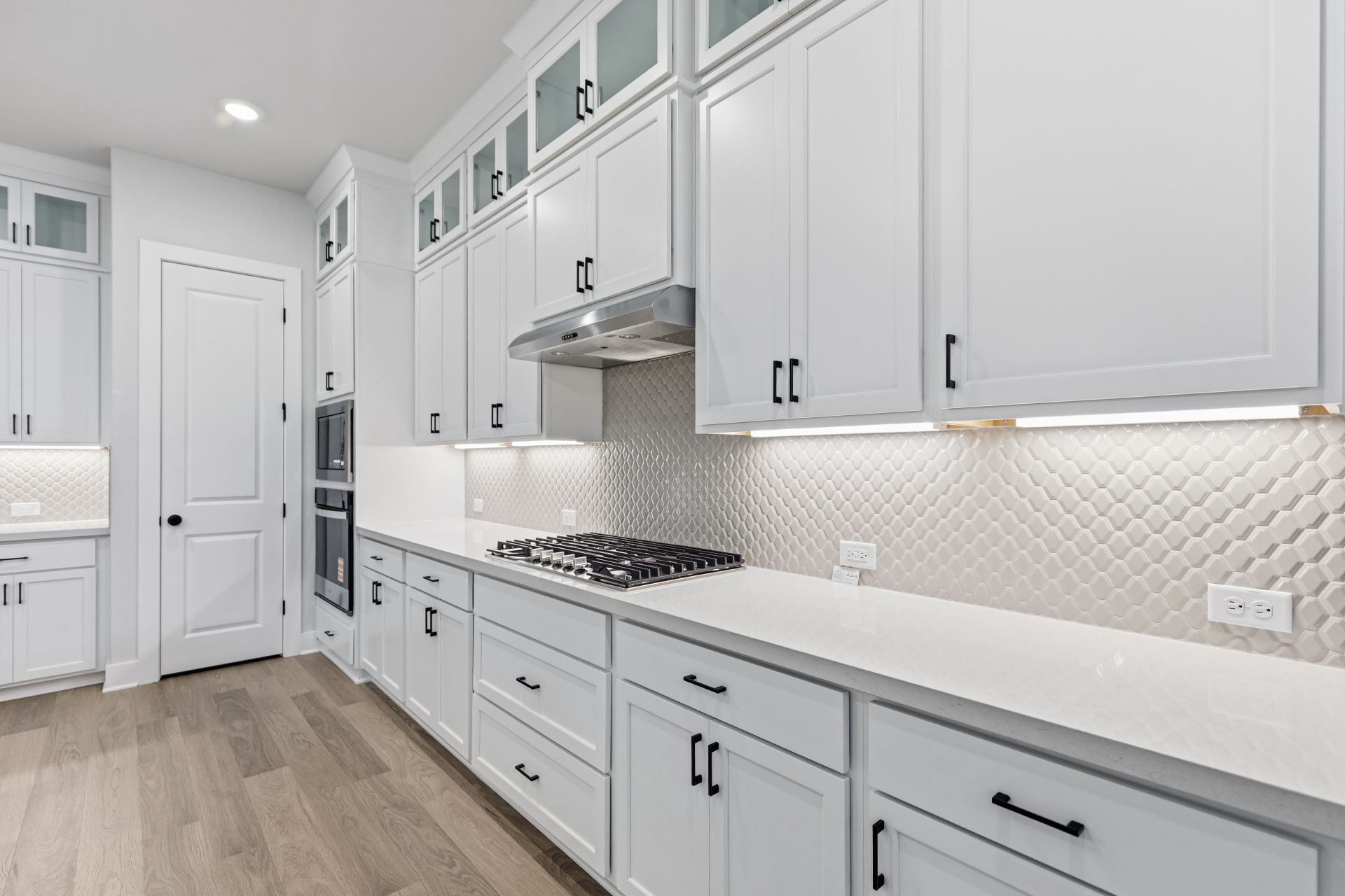 1713 Snowdrop Drive Georgetown, TX 78628 - Photo 9 of 35 a kitchen with white cabinets and a stove with wooden floor