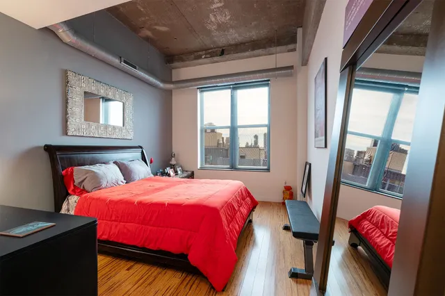 a bedroom with bed and a mirror