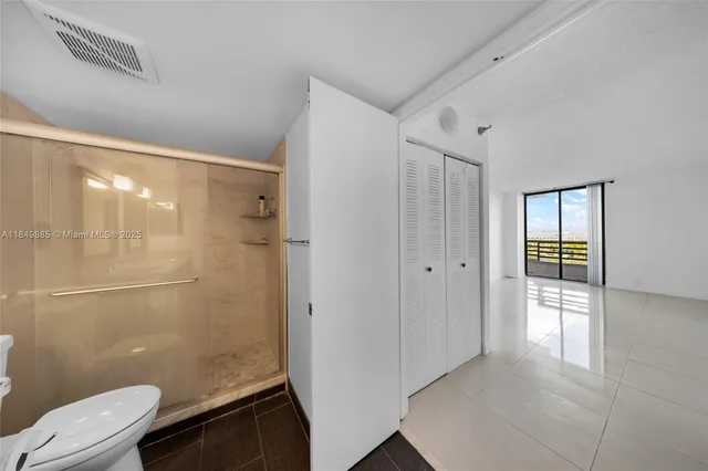 a view of an empty room with window and refrigerator