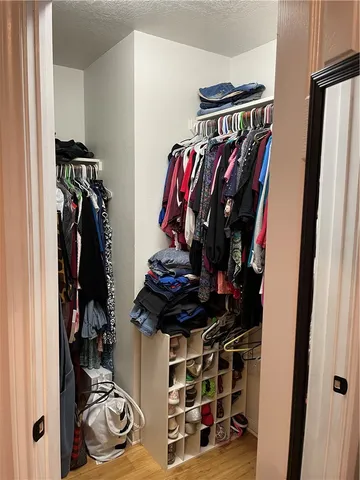 a view of walk in closet with clothes and shoes