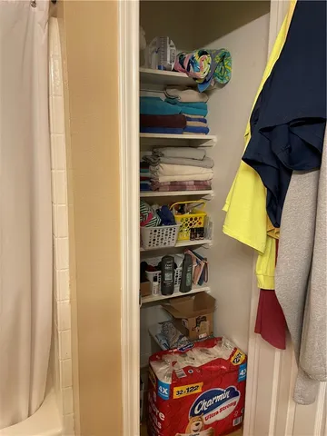 a view of walk in closet with clothes and shoes