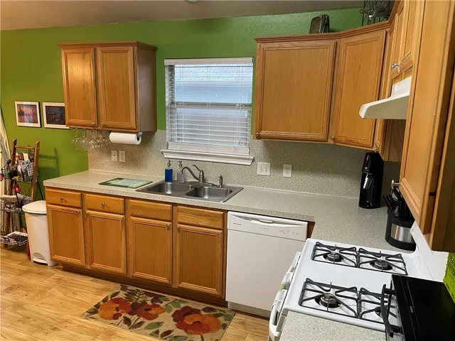 a kitchen with stainless steel appliances granite countertop a sink stove and cabinets