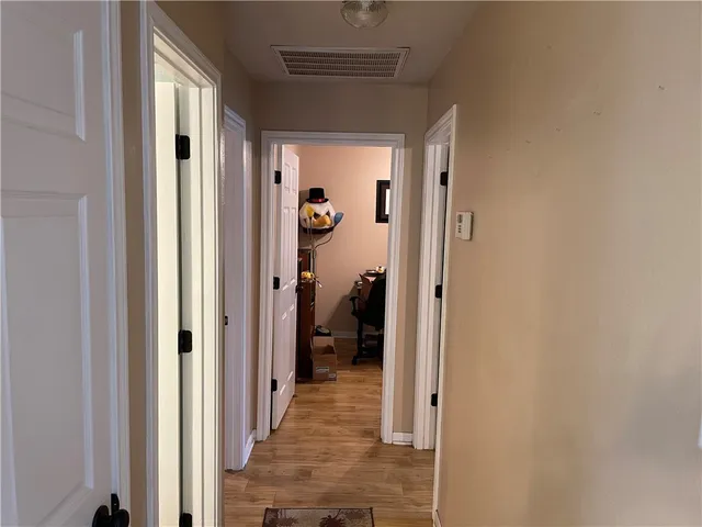 a view of a hallway with closet and a window