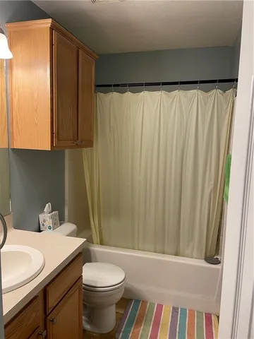 a bathroom with a sink a toilet and shower curtain