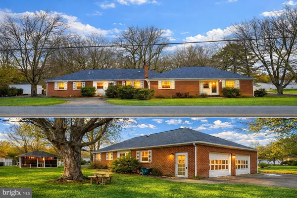 a view of a big house with a big yard and large trees