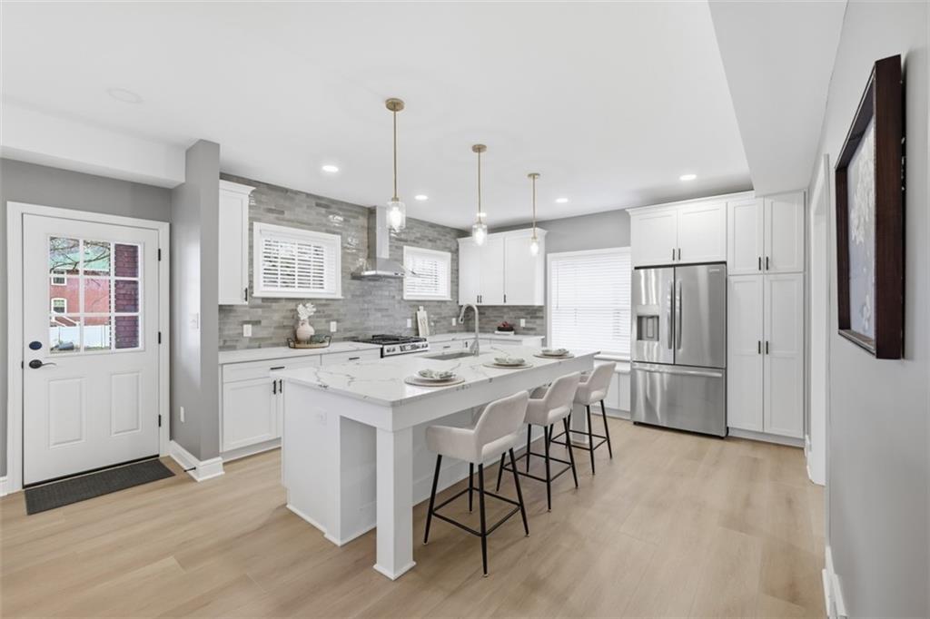 338 4th Street Beaver, PA 15009 - Photo 14 of 50 a kitchen with a refrigerator a sink dishwasher a stove and white cabinets with wooden floor