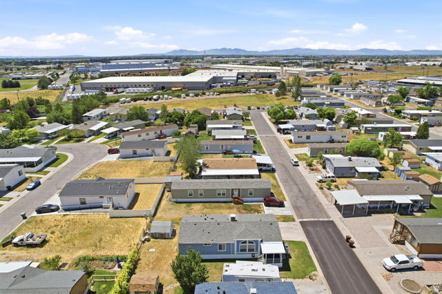 2491 Highway 89, Unit 614 Pleasant View, UT 84404 - Photo 25 of 27 Aerial perspective showcasing a residential community with paved streets and surrounding industrial structures