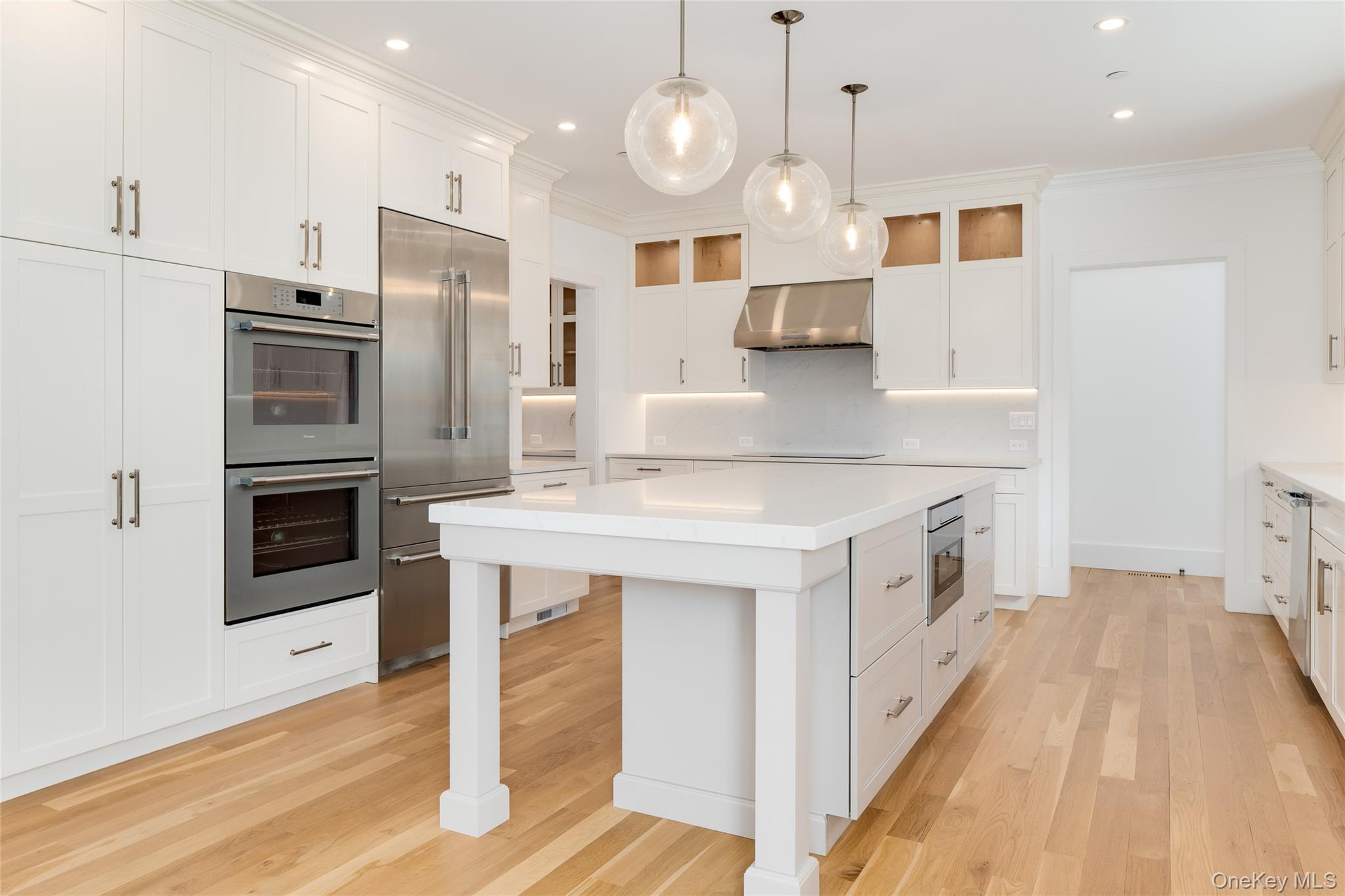 63 Buckout Road West Harrison, NY 10604 - Photo 11 of 34 a kitchen with stainless steel appliances kitchen island granite countertop a stove a sink a refrigerator and white cabinets with wooden floor