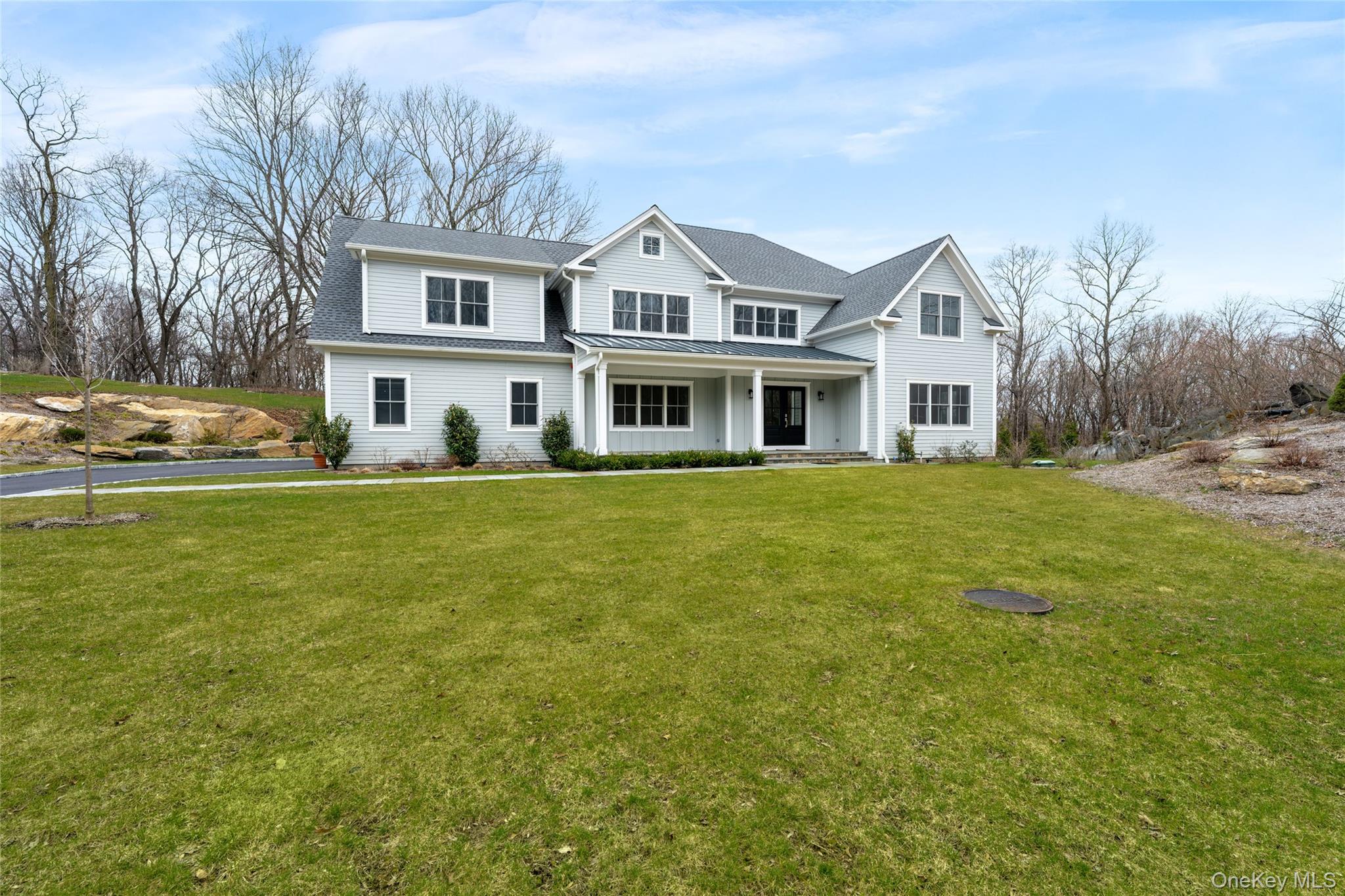 63 Buckout Road West Harrison, NY 10604 - Photo 2 of 34 a front view of a house with a garden and trees