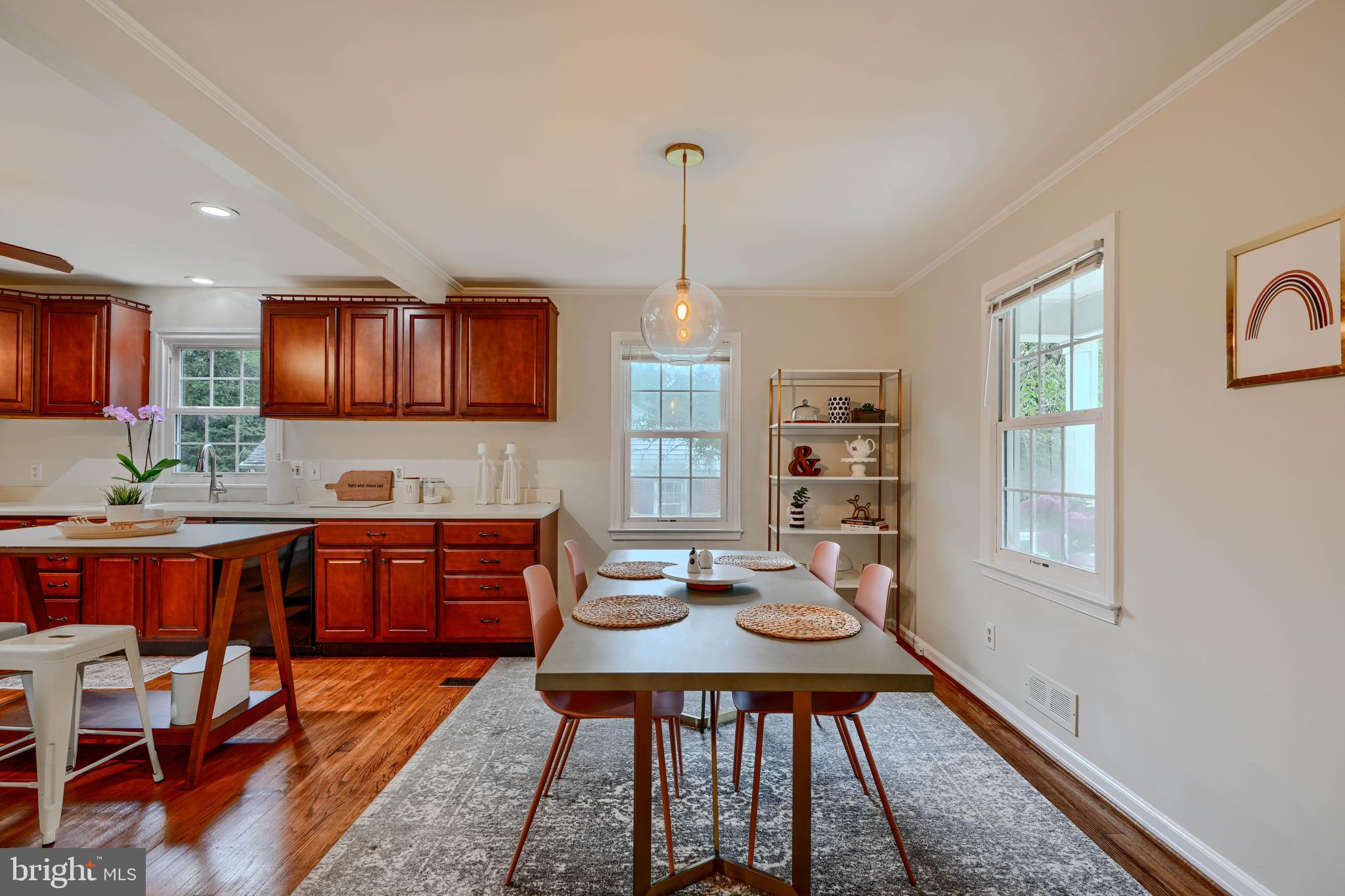 8808 Wolverton Road Baltimore, MD 21234 - Photo 14 of 57 a dinning room with stainless steel appliances granite countertop a stove kitchen island a dining table and chairs with wooden floor