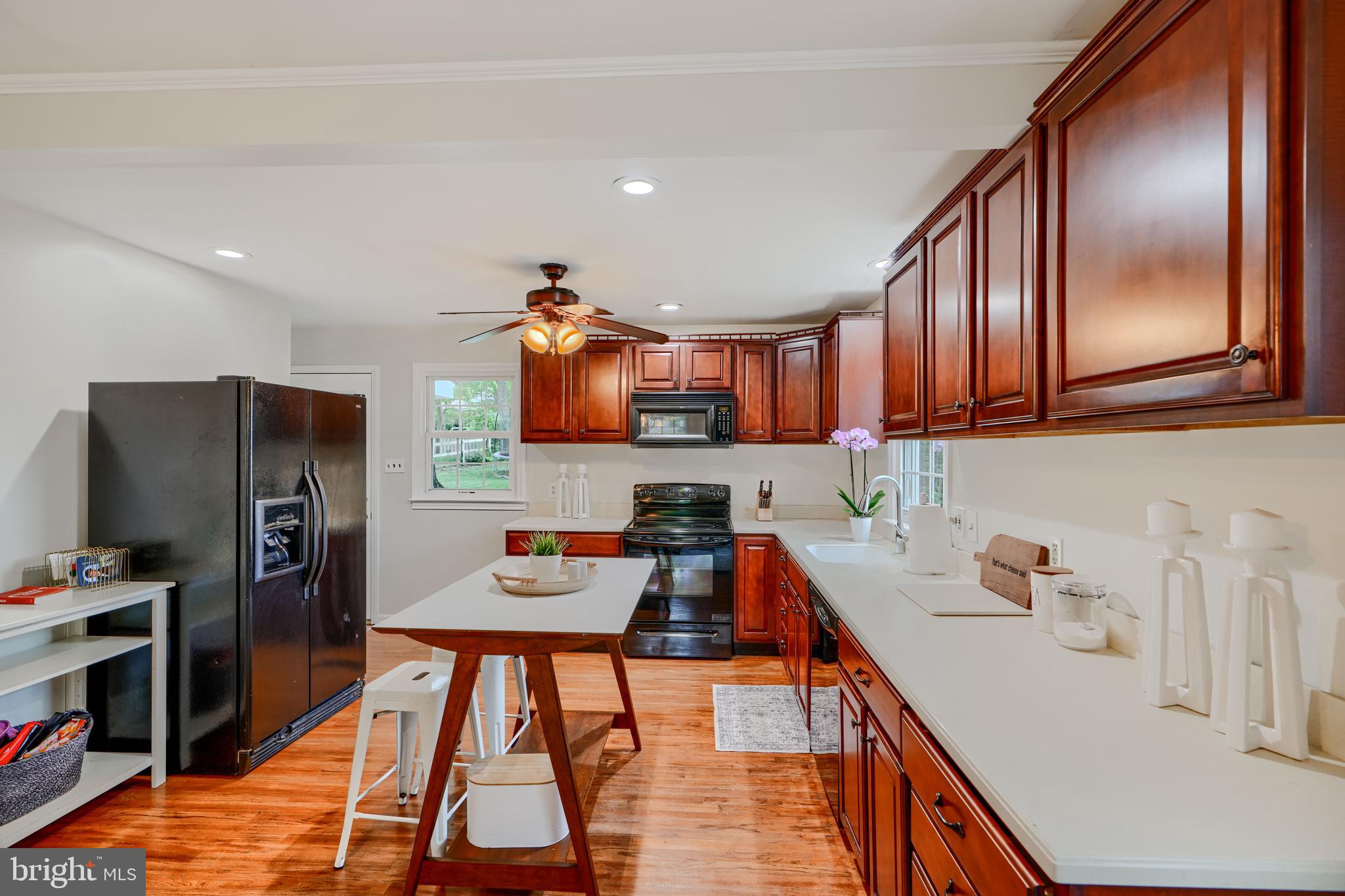 8808 Wolverton Road Baltimore, MD 21234 - Photo 16 of 57 a kitchen with stainless steel appliances granite countertop a refrigerator a stove and a sink with wooden floor