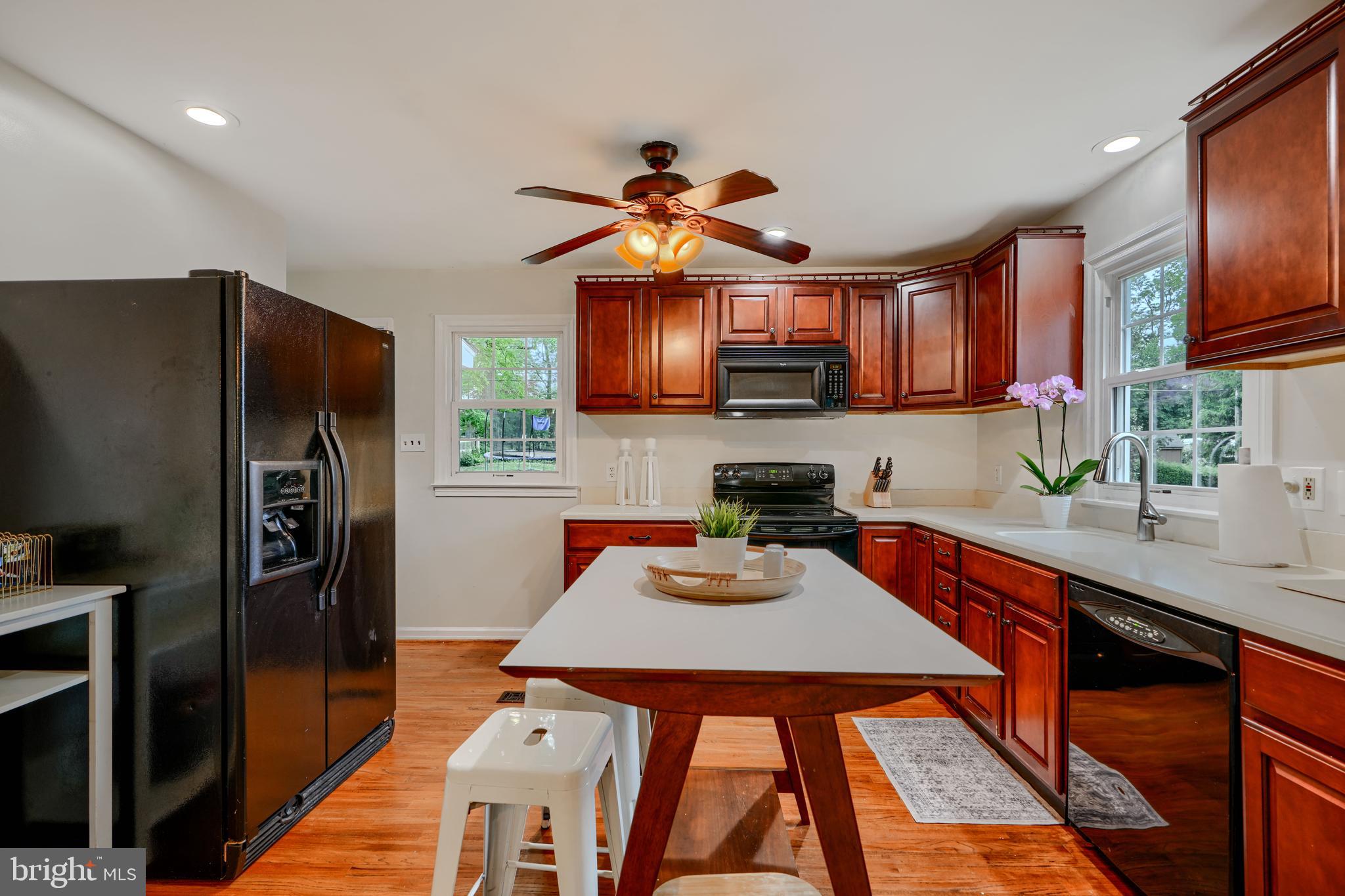 8808 Wolverton Road Baltimore, MD 21234 - Photo 17 of 57 a kitchen with stainless steel appliances granite countertop a refrigerator a sink dishwasher a stove with wooden cabinets and a dining table