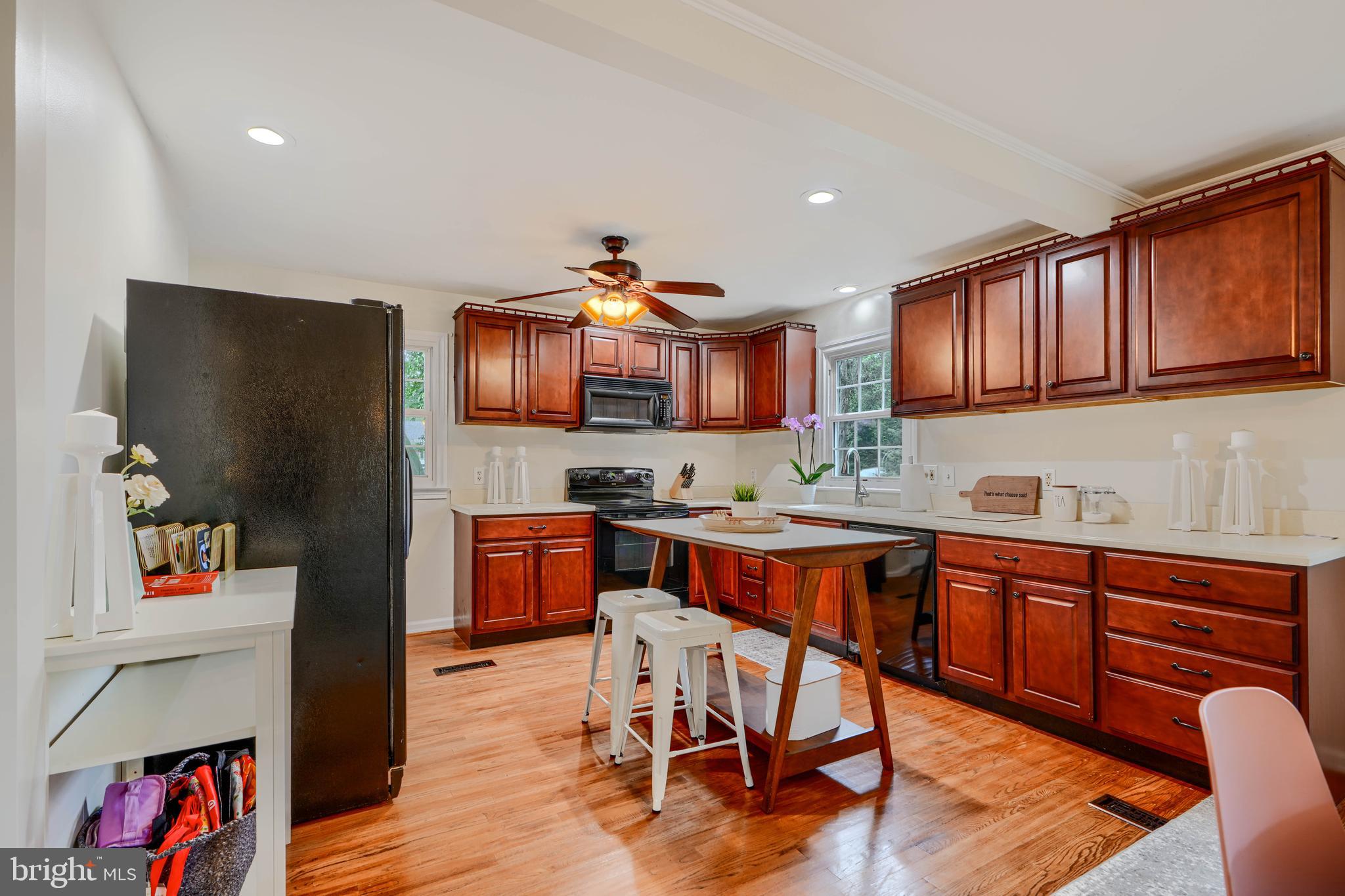 8808 Wolverton Road Baltimore, MD 21234 - Photo 20 of 57 a kitchen with stainless steel appliances granite countertop a refrigerator a sink dishwasher a dining table and chairs with wooden floor