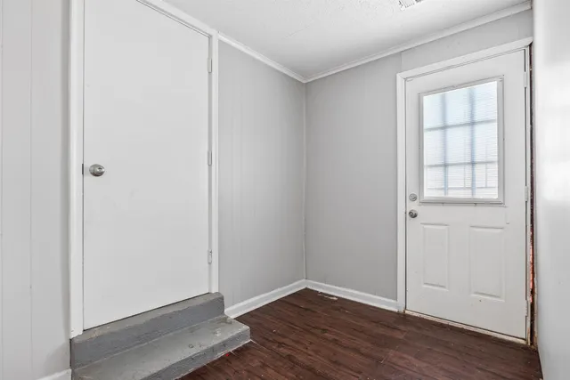 an empty room with wooden floor and closet
