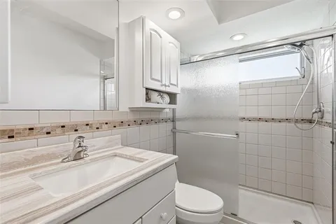 a bathroom with a sink a toilet and shower