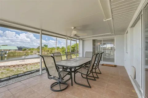 a dining room with furniture and a floor to ceiling window