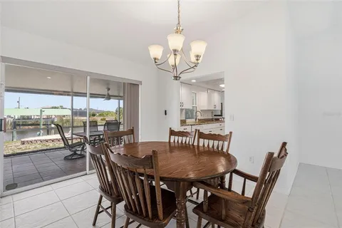 a dining room with wooden floor a chandelier a wooden table and chairs