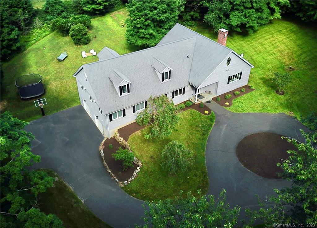 an aerial view of a house with a yard and green space
