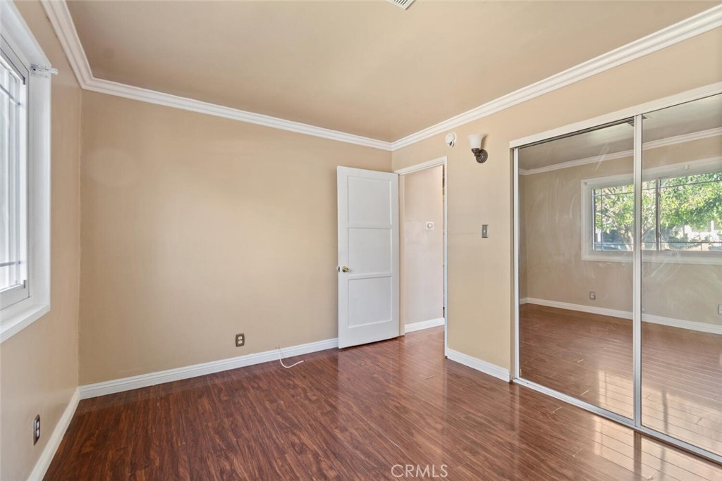 13438 Mercer Street Pacoima, CA 91331 - Photo 16 of 39 a view of an empty room with wooden floor and a window