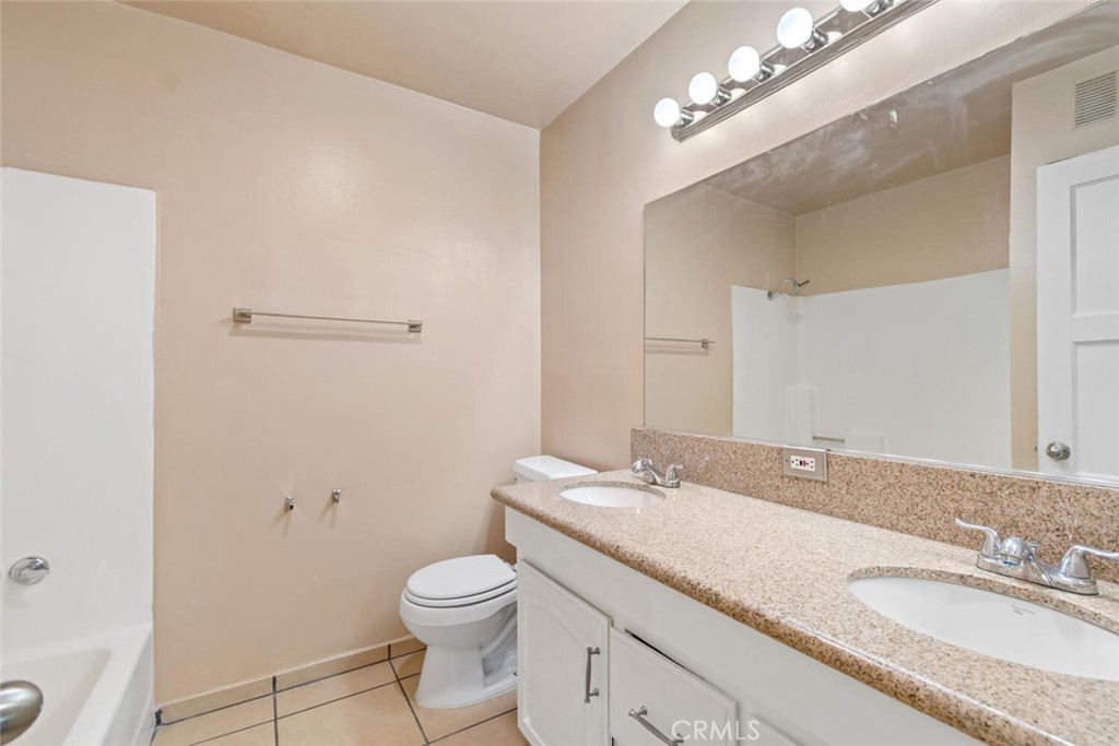 13438 Mercer Street Pacoima, CA 91331 - Photo 27 of 39 a bathroom with a granite countertop sink a toilet and a mirror