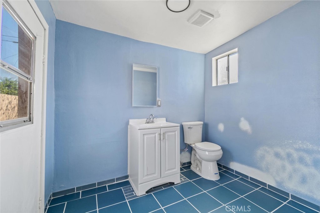 13438 Mercer Street Pacoima, CA 91331 - Photo 34 of 39 a bathroom with a toilet a sink and a window
