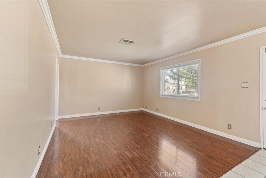 13438 Mercer Street Pacoima, CA 91331 - Photo 4 of 39 an empty room with wooden floor and windows