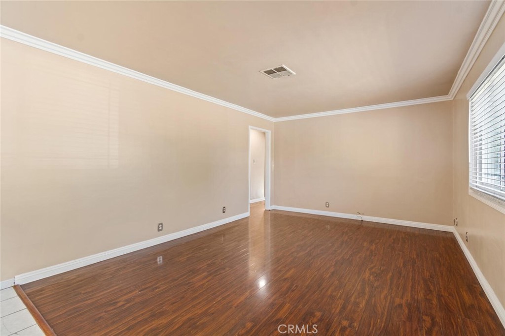13438 Mercer Street Pacoima, CA 91331 - Photo 5 of 39 an empty room with wooden floor and windows