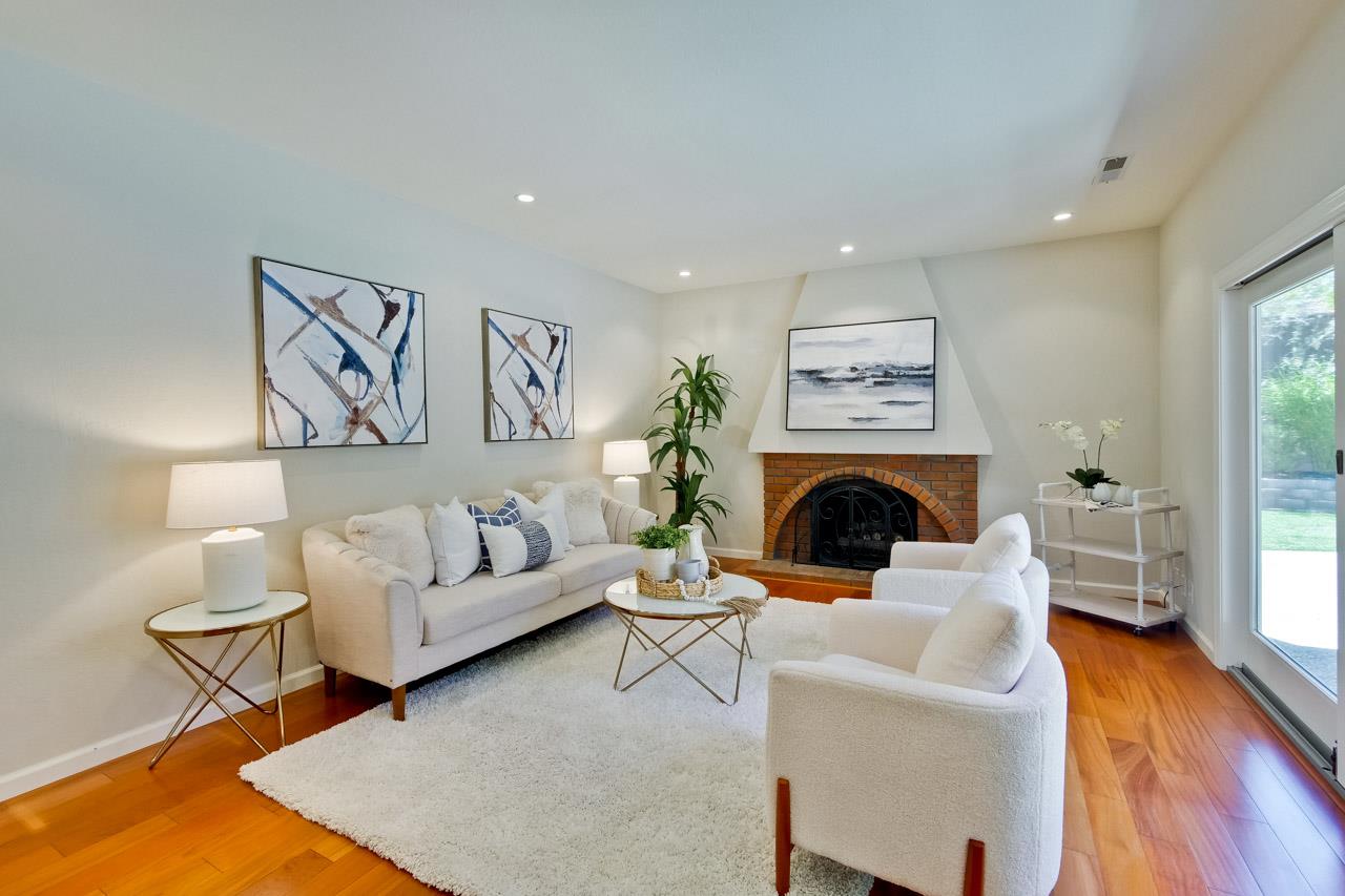 11131 Bubb Road Cupertino, CA 95014 - Photo 26 of 56 a living room with furniture a fireplace and a table with wooden floor