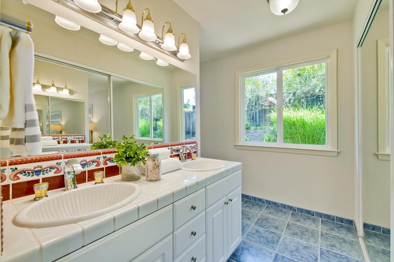 11131 Bubb Road Cupertino, CA 95014 - Photo 46 of 56 a bathroom with a sink a large mirror and a bathtub next to a window
