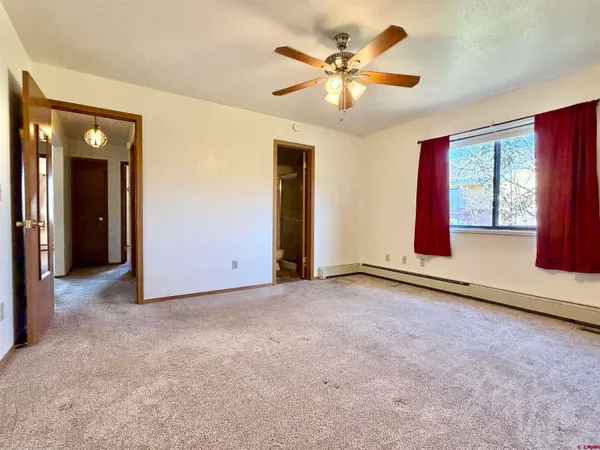 an empty room with windows and fan