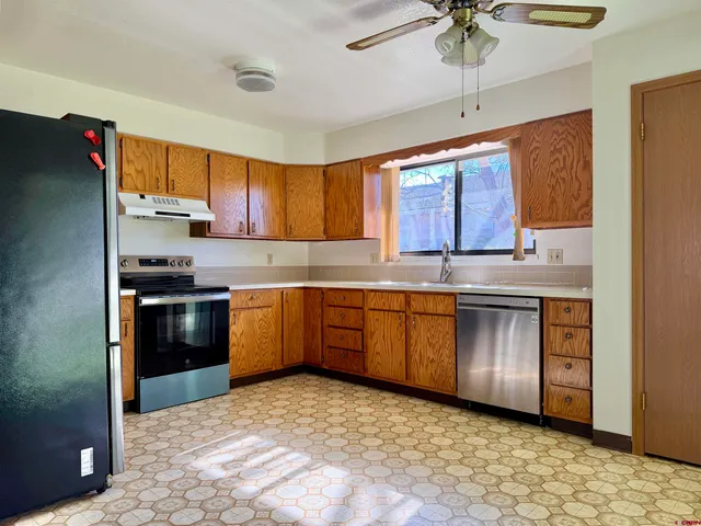 a kitchen with granite countertop a stove cabinets and a refrigerator